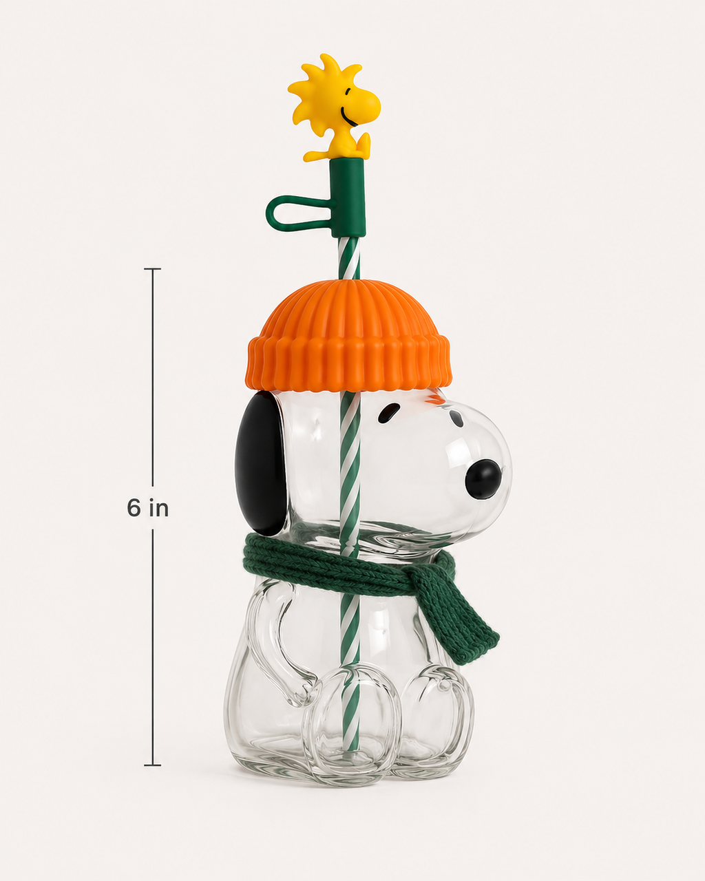 Angled view of the Pup-kin glass cup with orange pumpkin lid, green scarf, striped straw and 6-inch size guide.